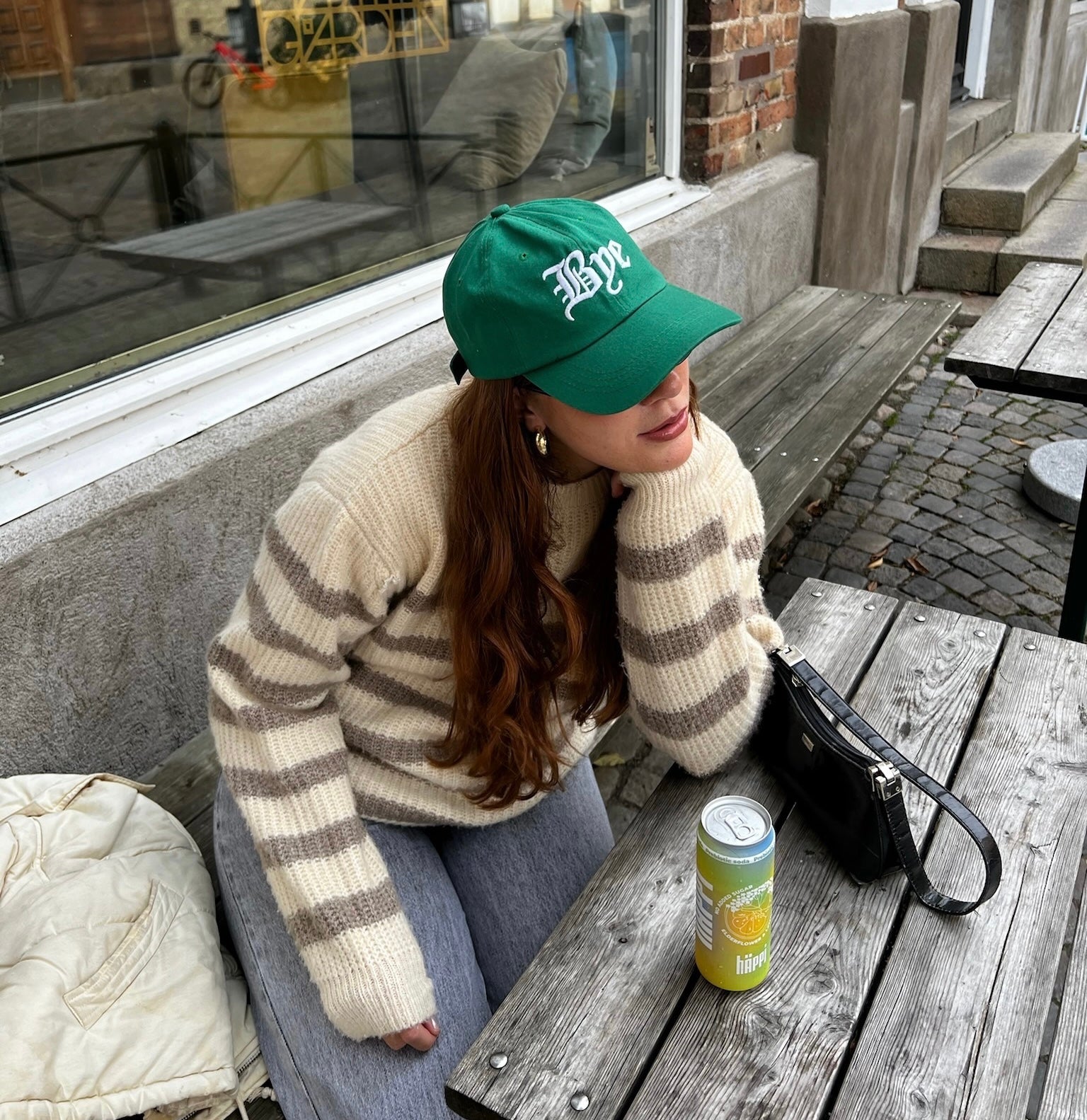 A cozy autumn moment: enjoying a häppi prebiotic soda at an outdoor café, perfect for boosting wellness with natural prebiotics this season.